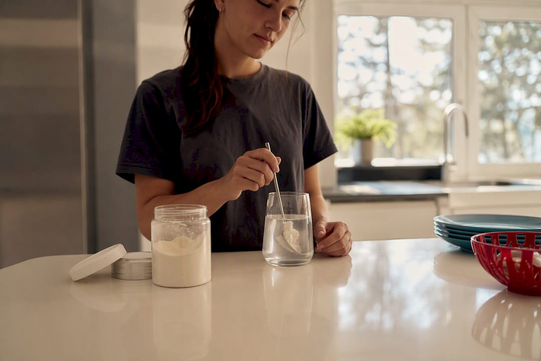 Hands stirring collagen supplement drink